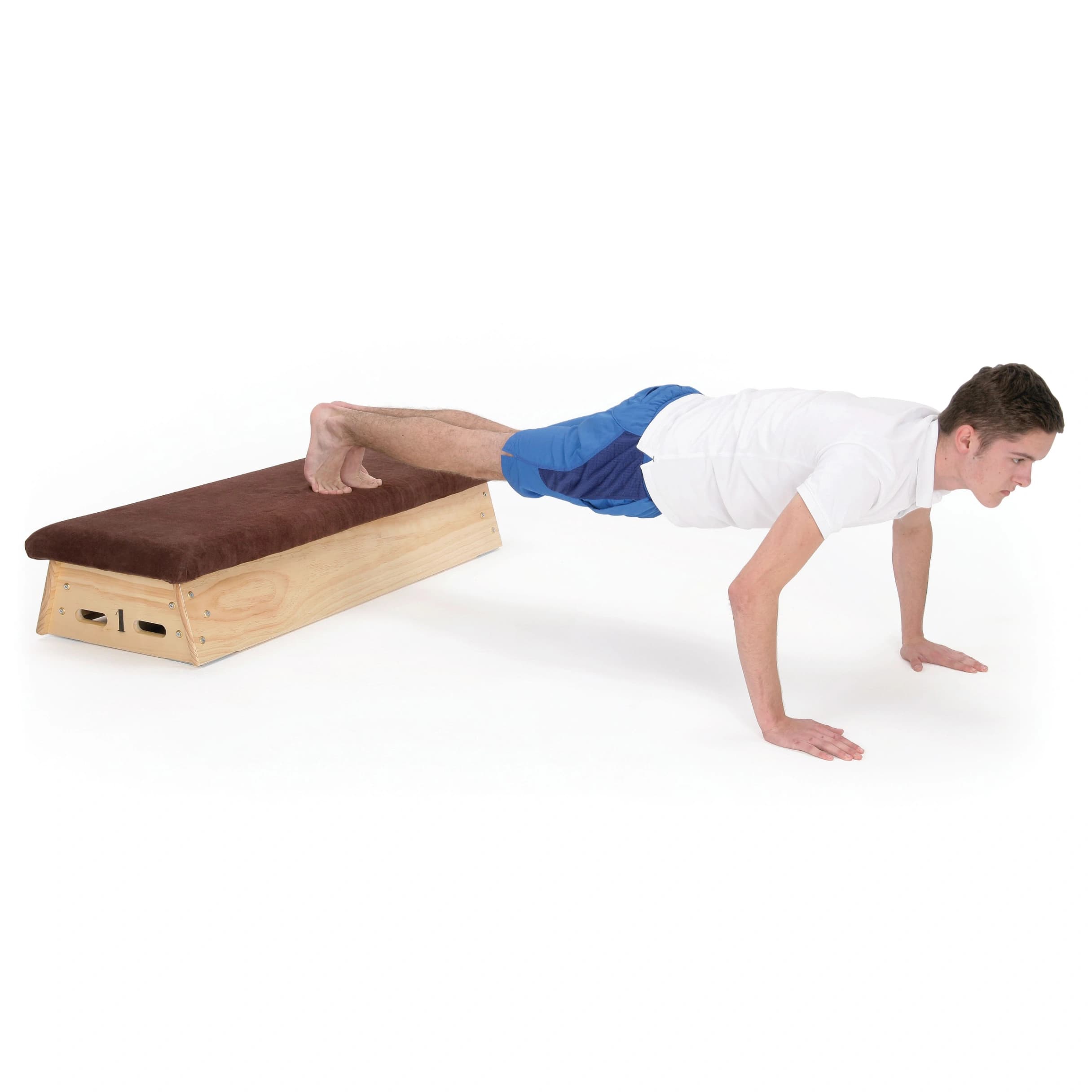Man in white shirt and blue shorts doing an elevated push-up with feet on a timber vaulting box topped in natural hide.